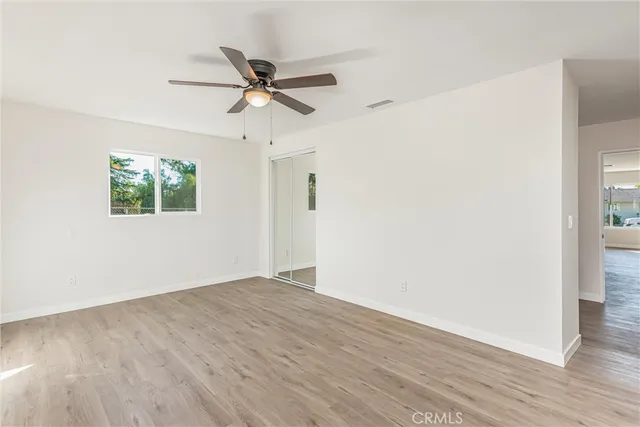 a view of a big room with wooden floor closet and windows
