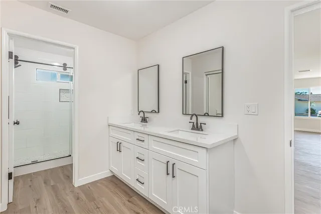 a spacious bathroom with double vanity a sink and a mirror