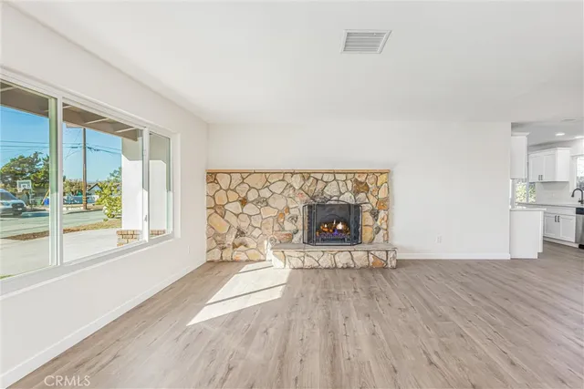 a view of wooden floor fire place and windows in a room