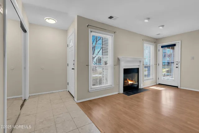 a view of an empty room with fire place and a window