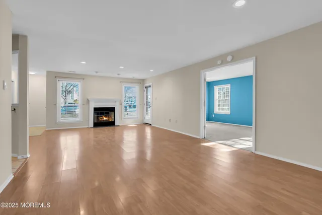 a view of empty room with wooden floor and fireplace