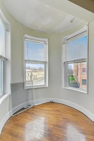 a view of a room with wooden floor and a window