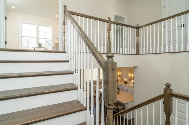 a view of staircase with railing and white walls