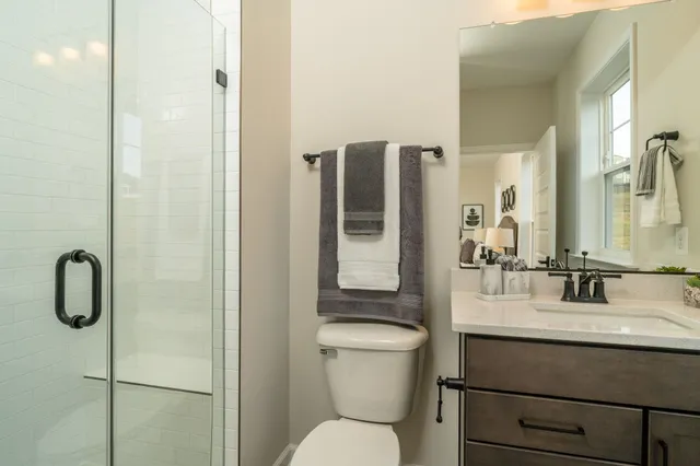 a bathroom with a granite countertop toilet sink and mirror