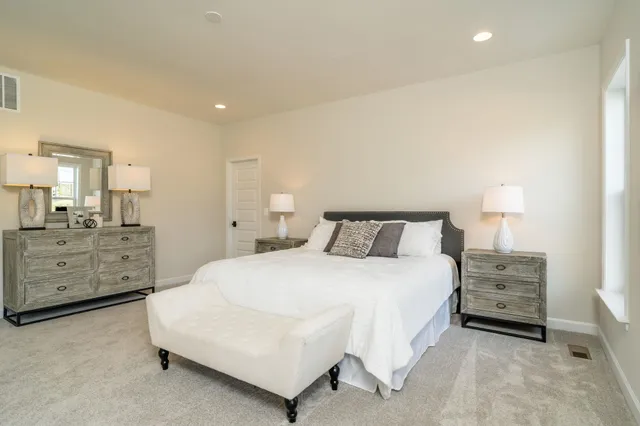a spacious bedroom with a bed and a cabinets