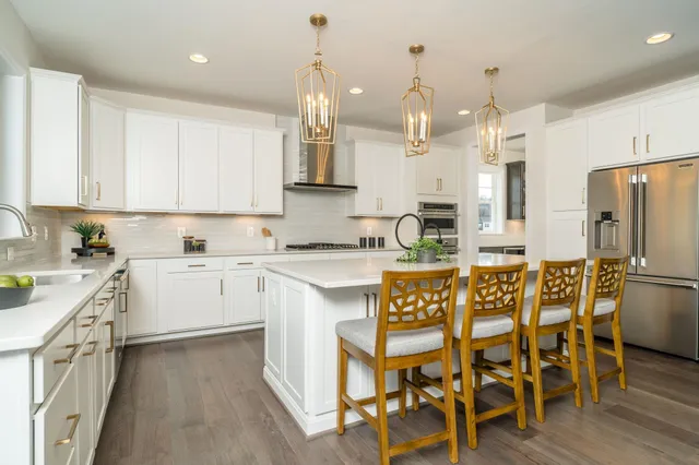 a kitchen with stainless steel appliances white cabinets sink and wooden floor