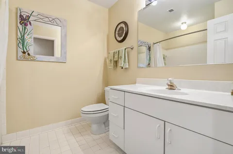 a bathroom with a toilet sink vanity and mirror