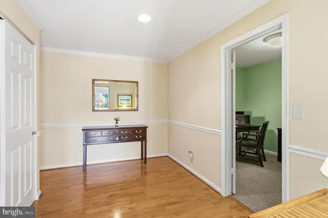 a hallway with a wooden floor and a chair