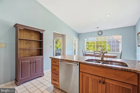 a kitchen with granite countertop a stove sink and refrigerator