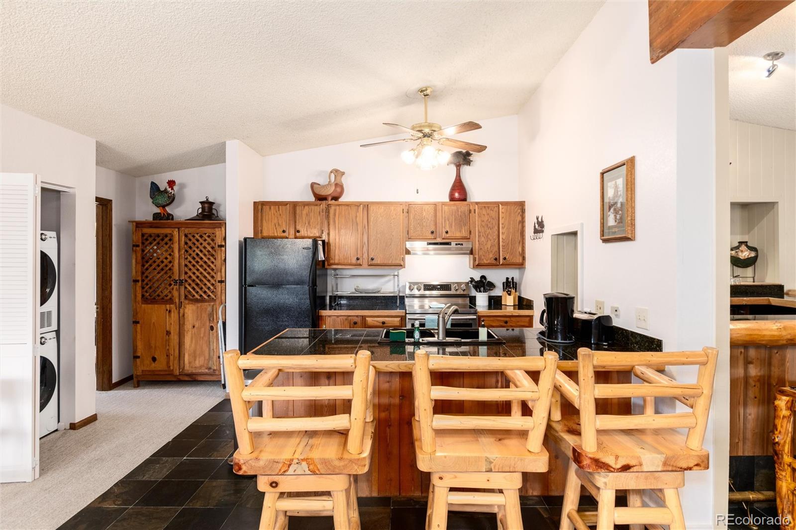490 Kings Crossing Road, Unit 631633 Winter Park, CO 80482 - Photo 16 of 43 a kitchen with stainless steel appliances kitchen island granite countertop a refrigerator and a stove top oven
