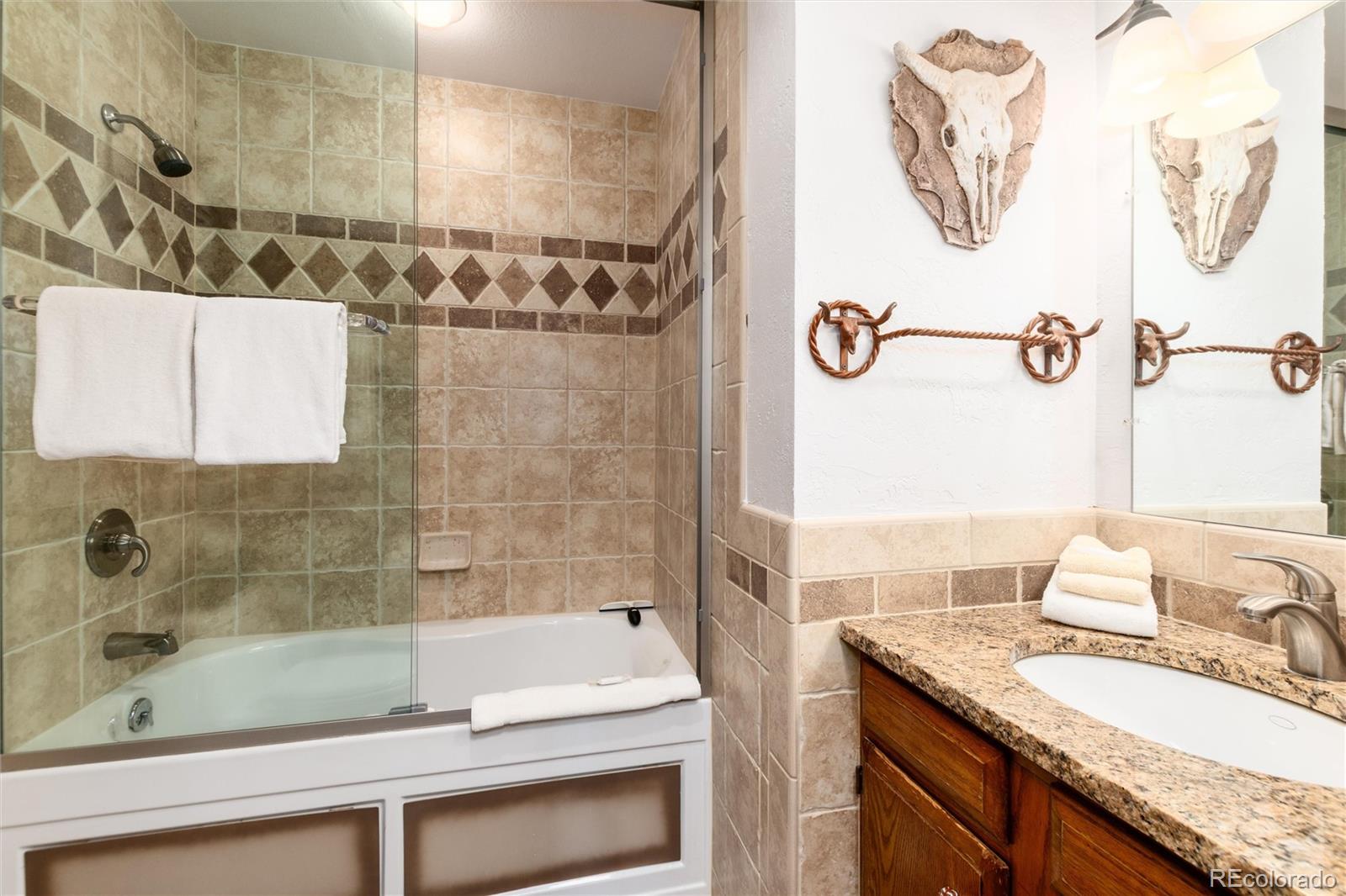 490 Kings Crossing Road, Unit 631633 Winter Park, CO 80482 - Photo 25 of 43 a bathroom with a granite countertop sink a toilet and shower