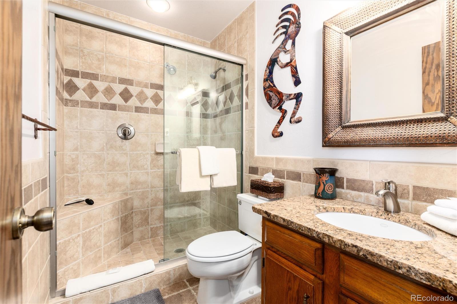 490 Kings Crossing Road, Unit 631633 Winter Park, CO 80482 - Photo 31 of 43 a bathroom with a granite countertop sink toilet and shower