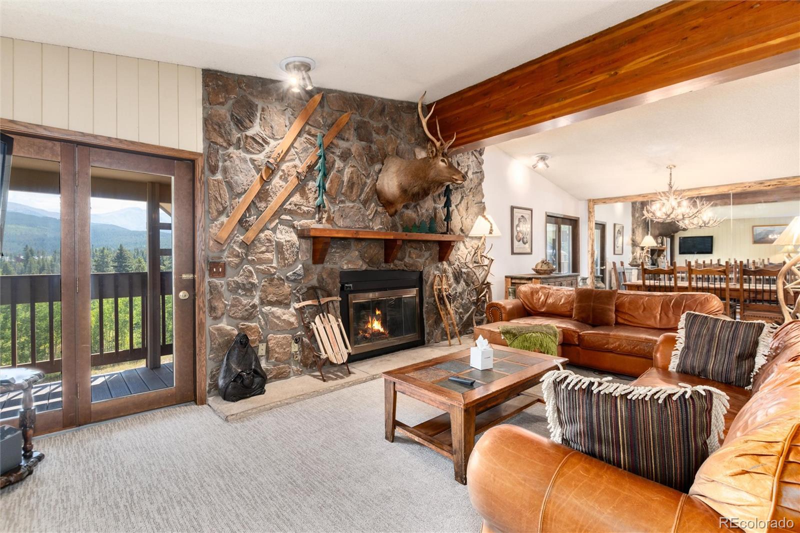 490 Kings Crossing Road, Unit 631633 Winter Park, CO 80482 - Photo 7 of 43 a living room with furniture a fireplace and a floor to ceiling window