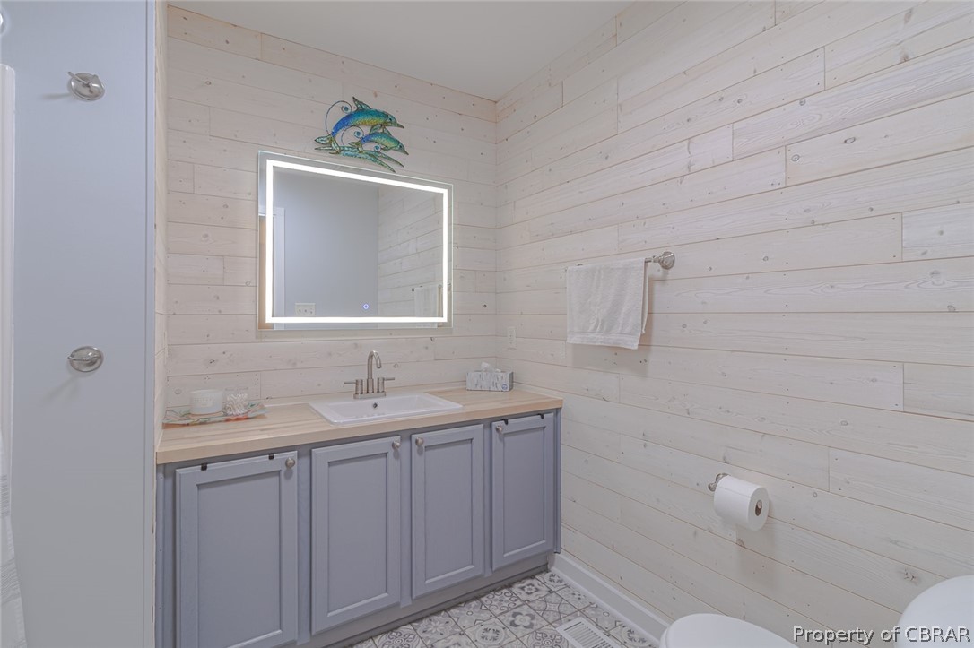 11654 Courthouse Road Lancaster, VA 22503 - Photo 19 of 35 a bathroom with a granite countertop sink mirror and toilet