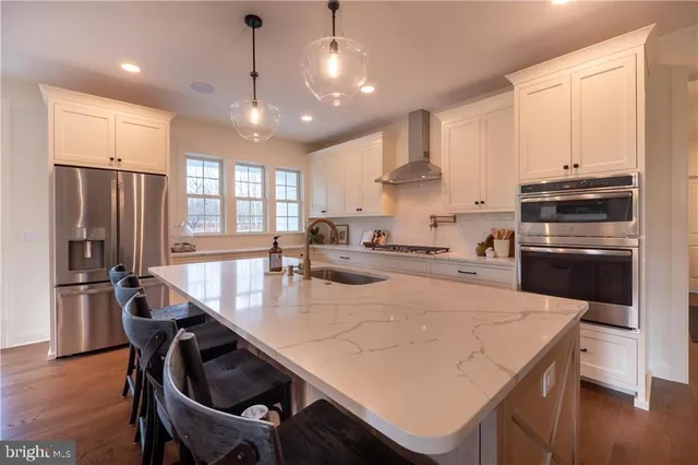 a kitchen with refrigerator cabinets dining table and wooden floor