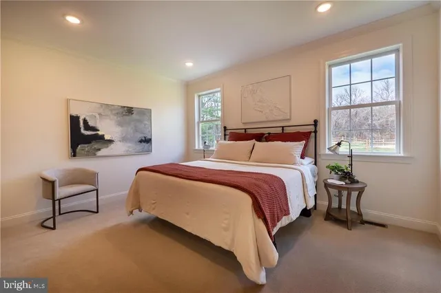 a bedroom with a bed chair and window