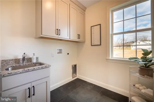 a kitchen with stainless steel appliances granite countertop a sink a stove and a white cabinets with wooden floor