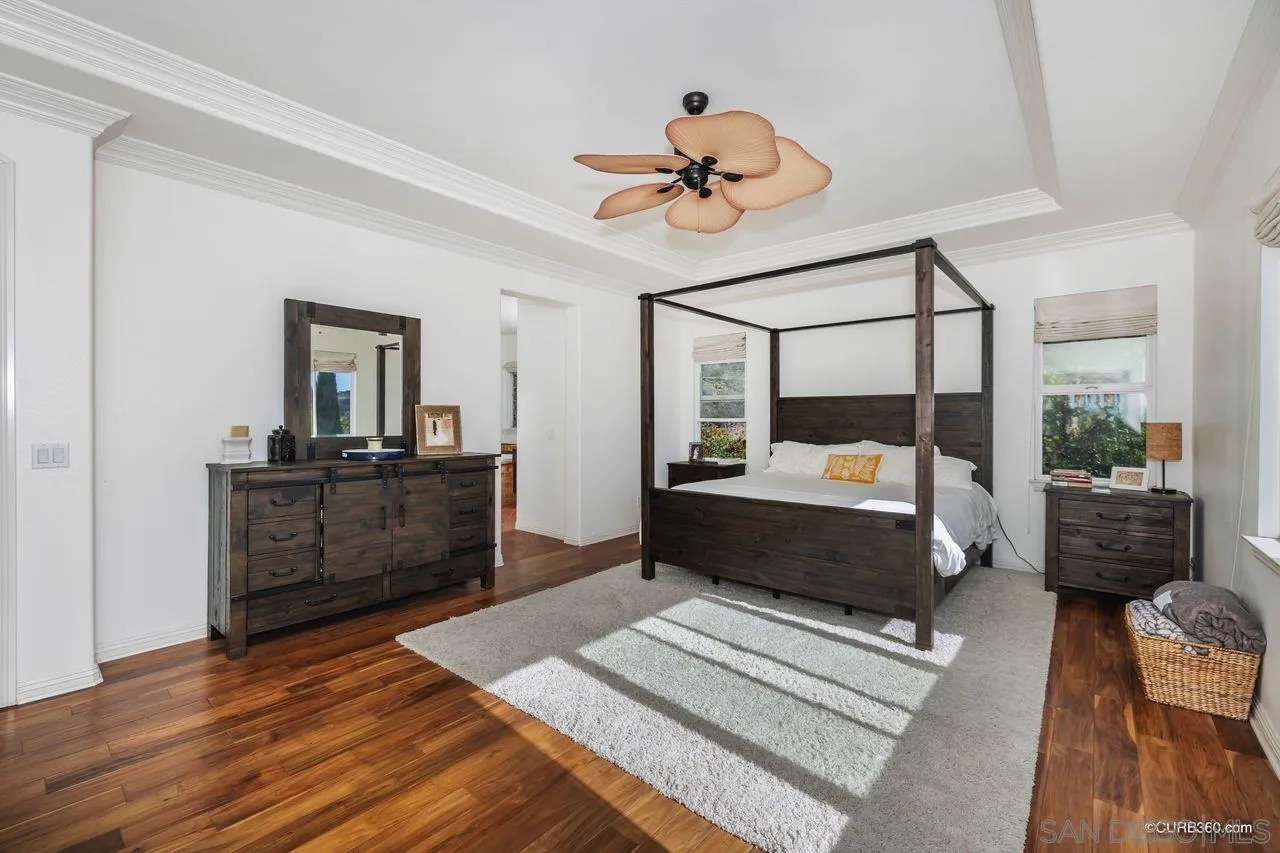 16029 Cayenne Ridge Road San Diego, CA 92127 - Photo 24 of 37 a bedroom with a large bed and a chandelier