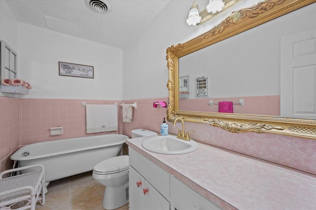 203 Main Street Rosebud, TX 76570 - Photo 11 of 35 a bathroom with a granite countertop sink mirror vanity and toilet