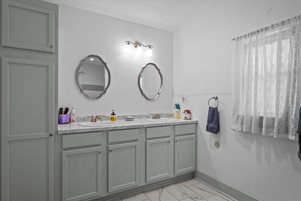 203 Main Street Rosebud, TX 76570 - Photo 17 of 35 a bathroom with a double vanity sink and a mirror