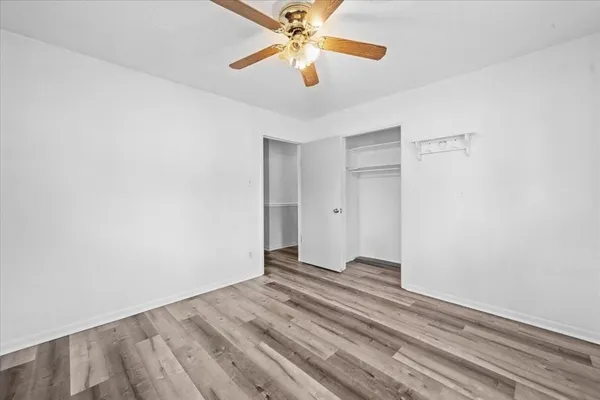 an empty room with windows and fan