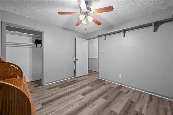 a view of room with a ceiling fan and wooden floor