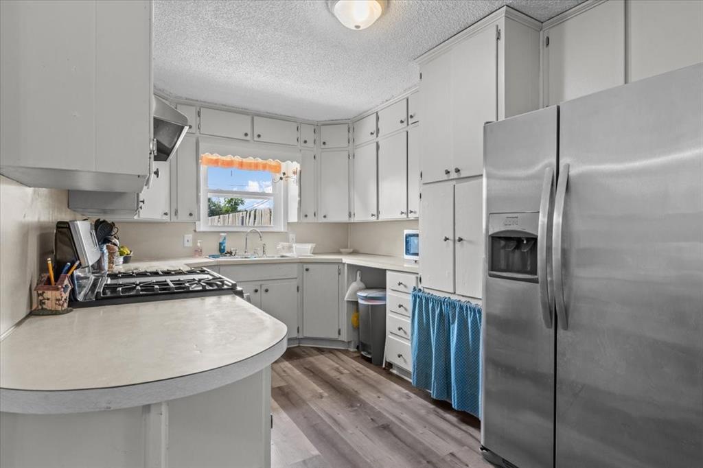 203 Main Street Rosebud, TX 76570 - Photo 5 of 35 a kitchen with stainless steel appliances a refrigerator sink and white cabinets