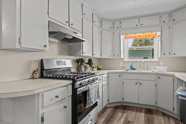a kitchen with stainless steel appliances a refrigerator sink and white cabinets
