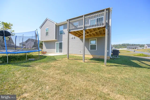 a view of a house with backyard porch and a small yard