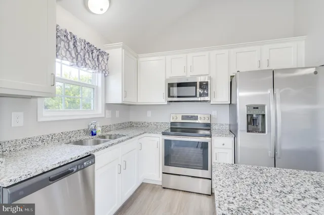 a kitchen with a sink stove microwave and refrigerator