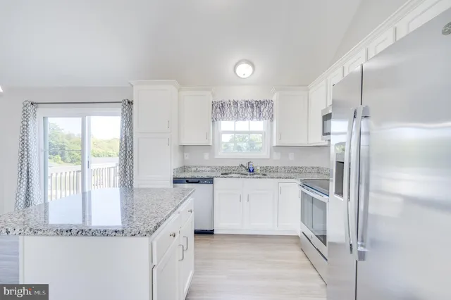 a kitchen with granite countertop a sink stove and refrigerator
