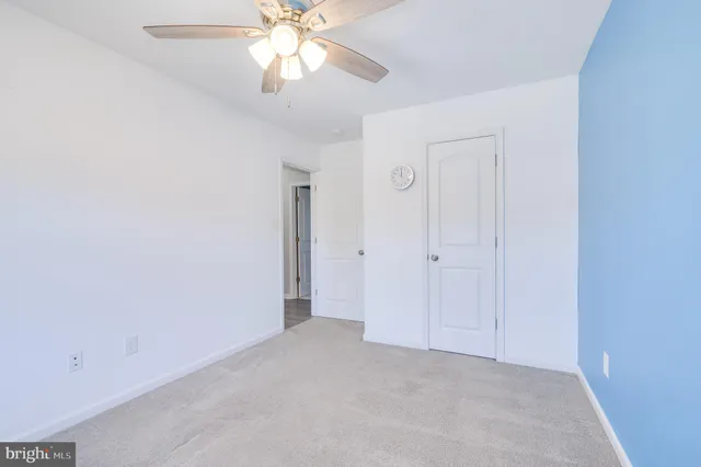 an empty room with a fan and a fan