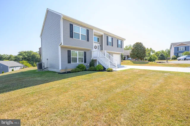 a front view of house with yard and trees in the background