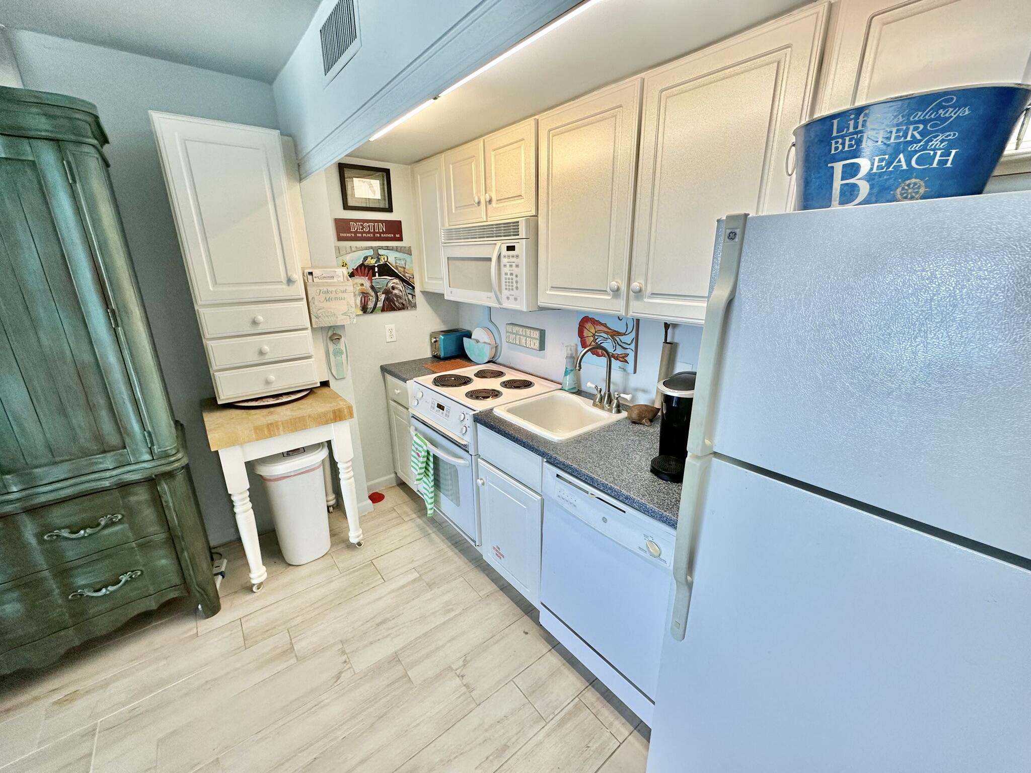 4280 Beachside 2, Unit 280 Miramar Beach, FL 32550 - Photo 11 of 34 a kitchen with stainless steel appliances a refrigerator a sink a stove and white cabinets