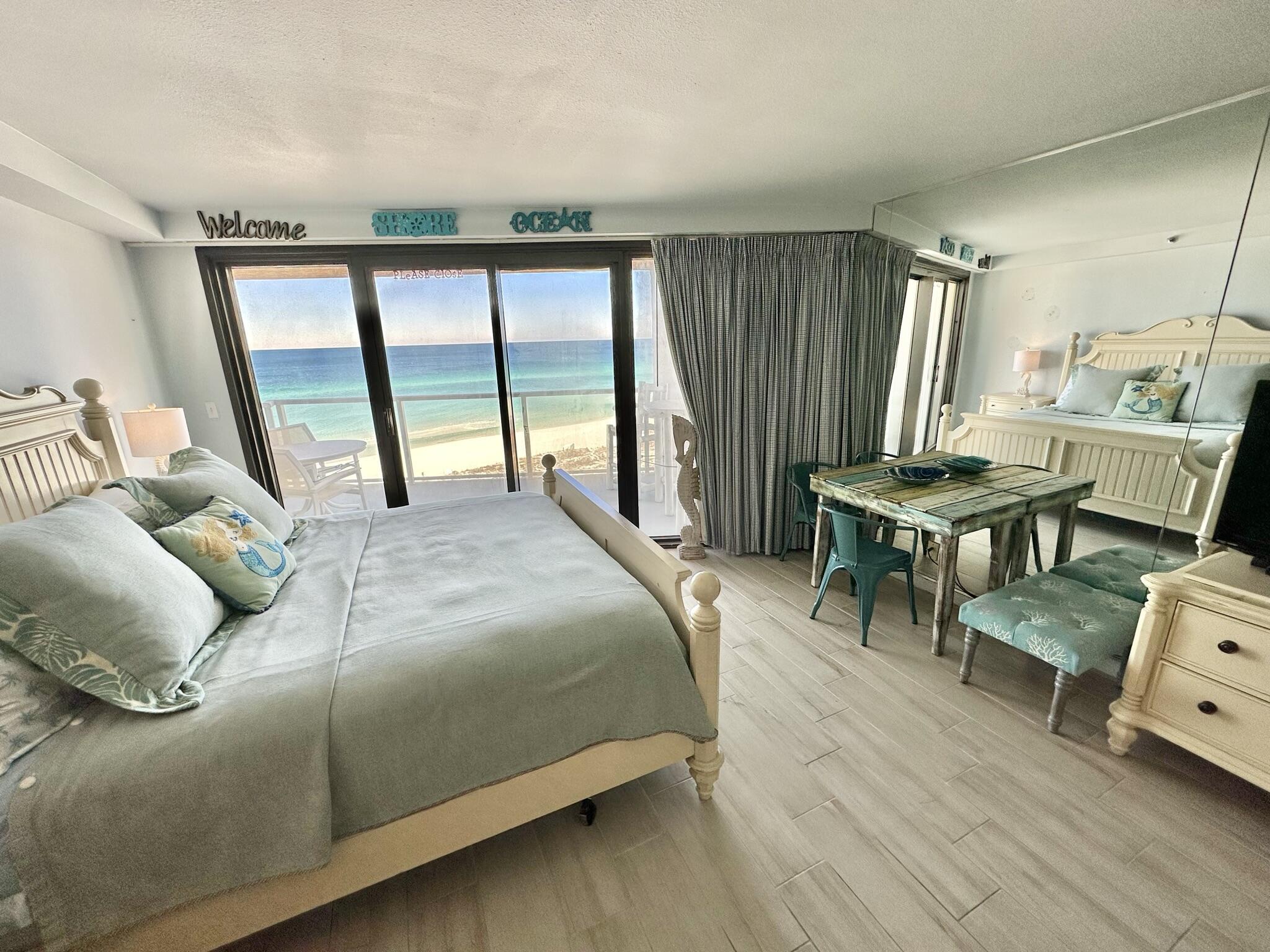 4280 Beachside 2, Unit 280 Miramar Beach, FL 32550 - Photo 17 of 34 a bedroom with a bed a table and large windows