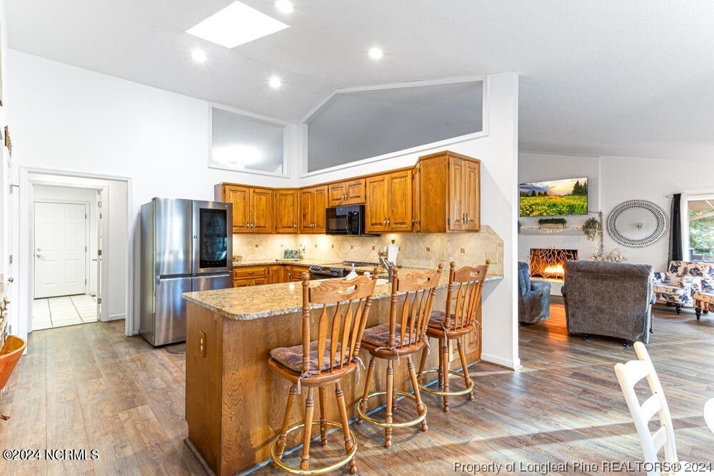 Undisclosed Address West End, NC 27376 - Photo 15 of 49 a kitchen with stainless steel appliances kitchen island granite countertop a refrigerator and microwave