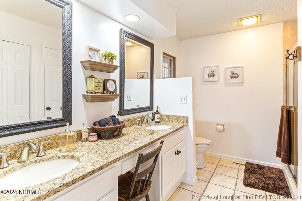 Undisclosed Address West End, NC 27376 - Photo 25 of 49 a bathroom with a granite countertop sink a mirror and a shower