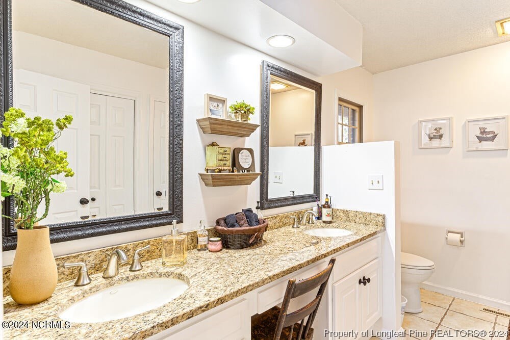 Undisclosed Address West End, NC 27376 - Photo 26 of 49 a bathroom with a granite countertop sink and a mirror