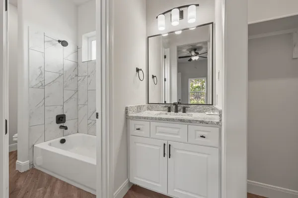 a bathroom with a bathtub a sink and a mirror