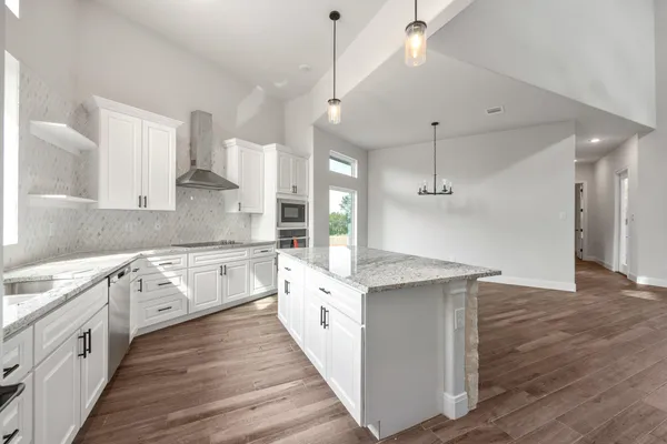 a large white kitchen with a white stove top oven and sink