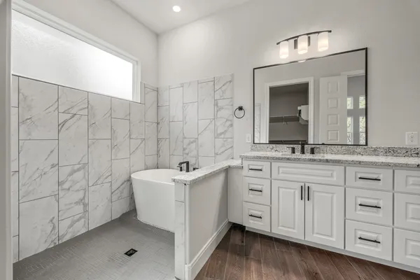 a spacious bathroom with a double vanity sink a mirror and a shower