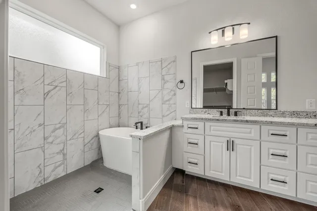 a spacious bathroom with a double vanity sink a mirror and a shower