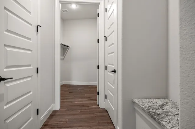 a view of a hallway with wooden floor and closet