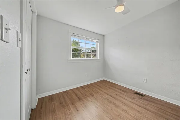 an empty room with wooden floor and windows