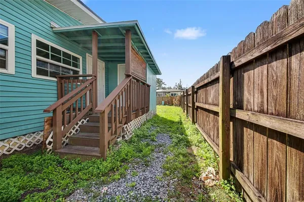 a view of a house with backyard and wooden fence