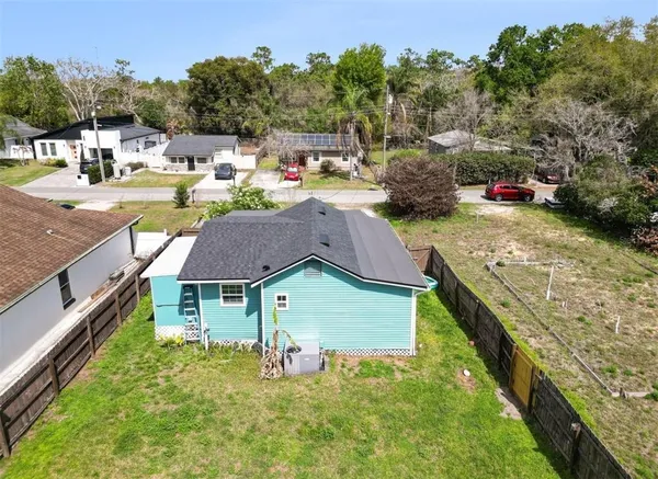 a aerial view of a house with swimming pool and large trees