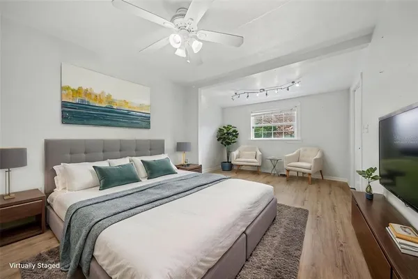 a spacious bedroom with a bed and a flat screen tv