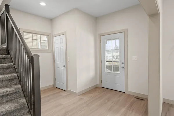 a view of an entryway with wooden floor and stairs