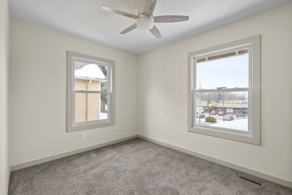 an empty room with windows and closet