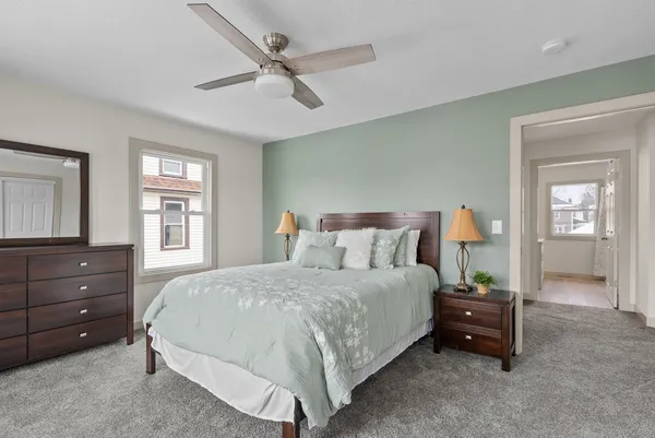 a bedroom with a bed and a mirror on dresser